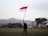 a man holding a flag in a field