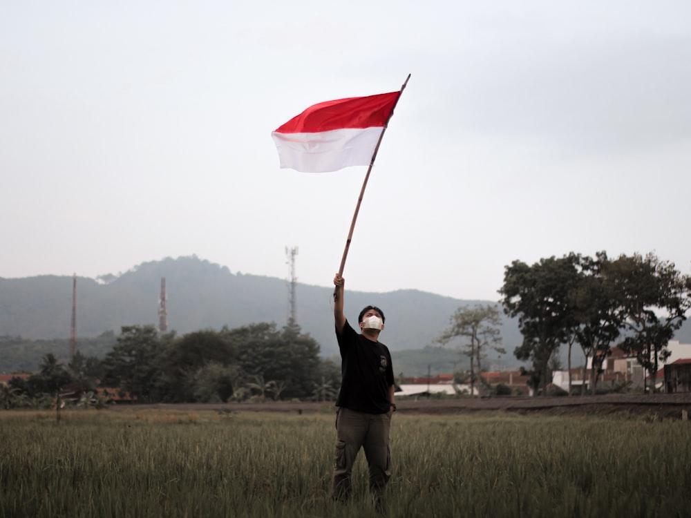 a man holding a flag in a field