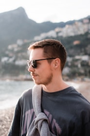 a man with a scarf around his neck on the beach