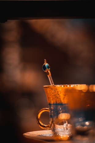 Close-up of a sleek glass cup with a delicate handle catching the light.