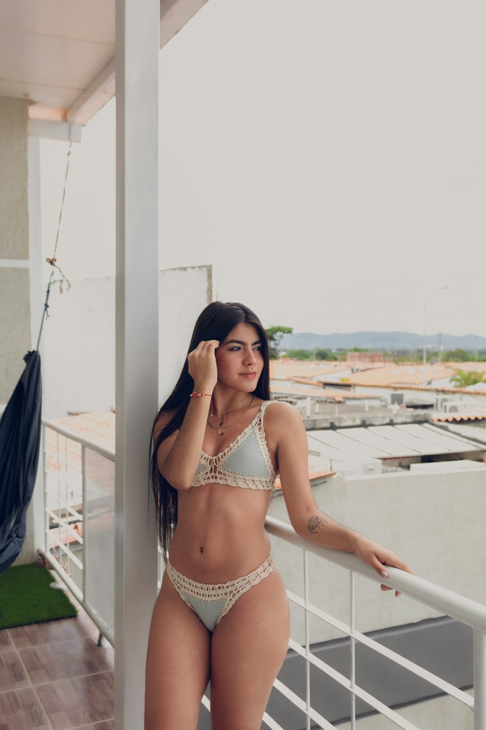 Una mujer en bikini parada en un balcón