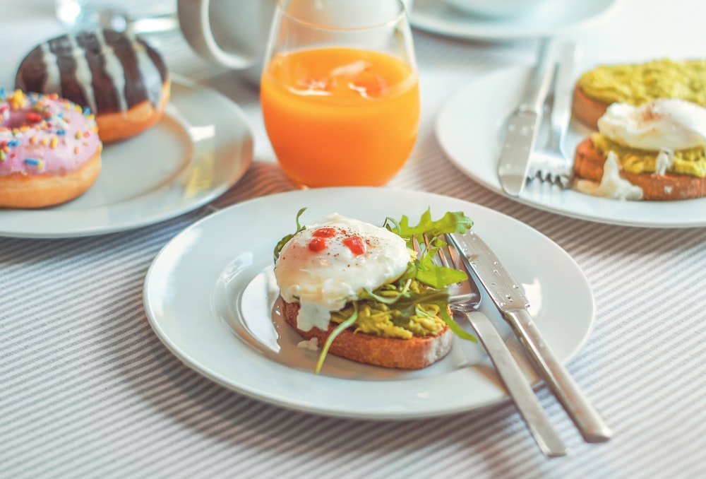 a plate of food on a table with a glass of orange juice