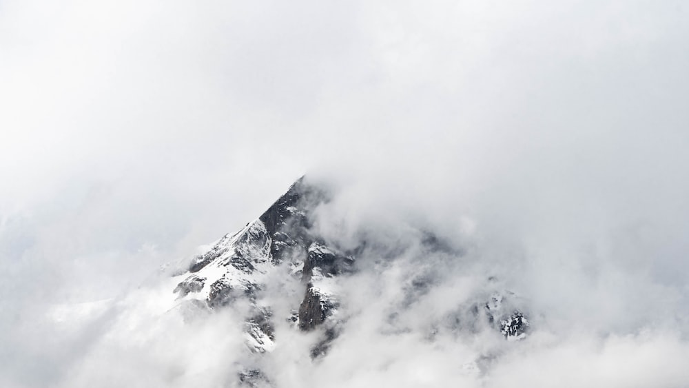 a mountain covered in clouds and snow