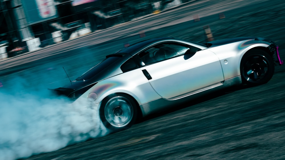 a silver sports car with a lot of smoke coming out of it