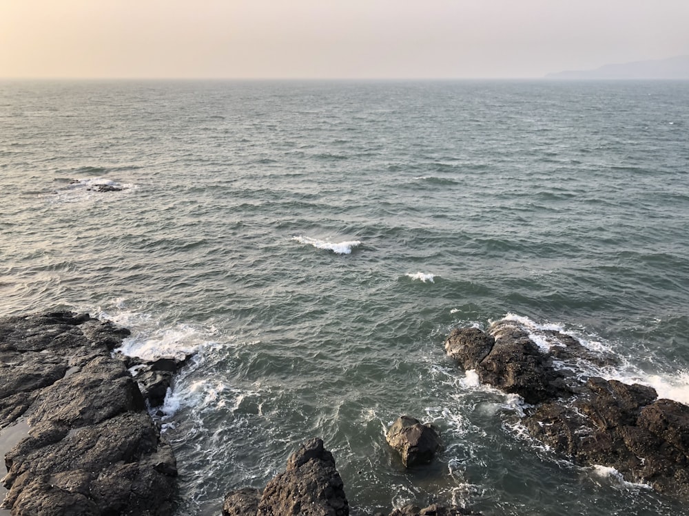 a body of water with rocks in the foreground