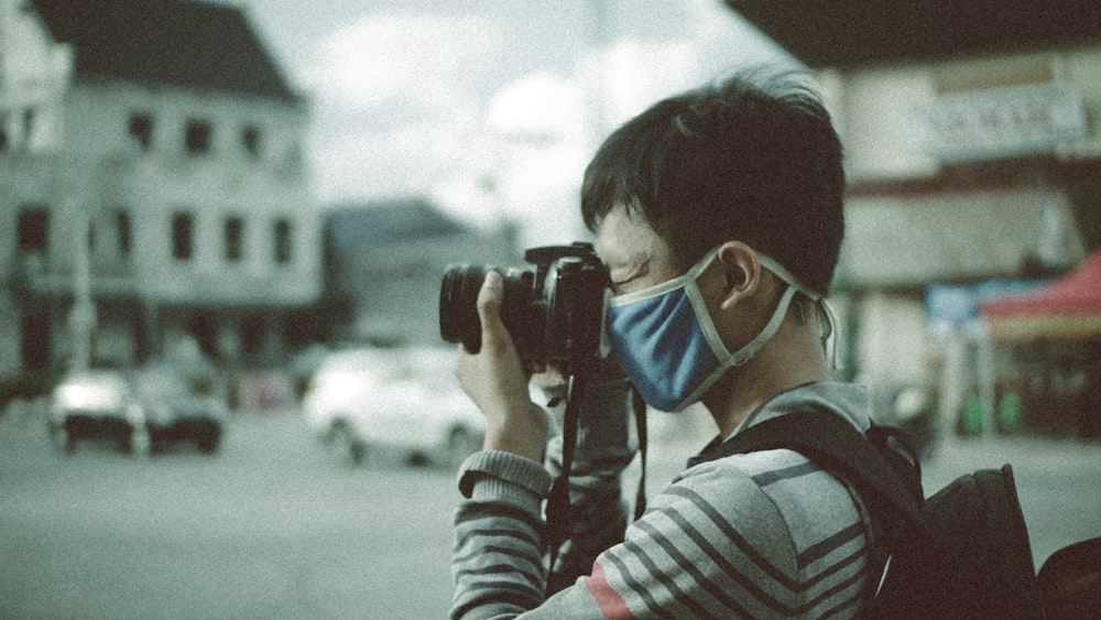 a man wearing a face mask and holding a camera