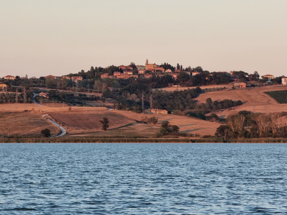 a body of water with a hill in the background