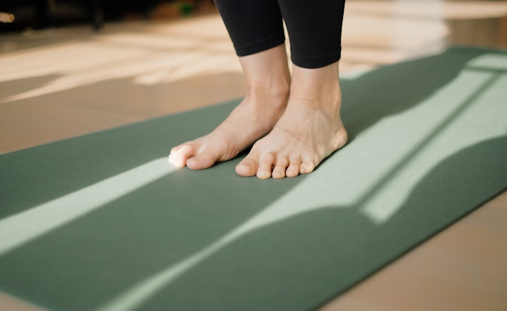 a person standing on a yoga mat on the floor