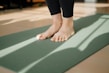 a person standing on a yoga mat on the floor