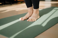 a person standing on a yoga mat on the floor