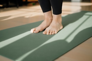 a person standing on a yoga mat on the floor