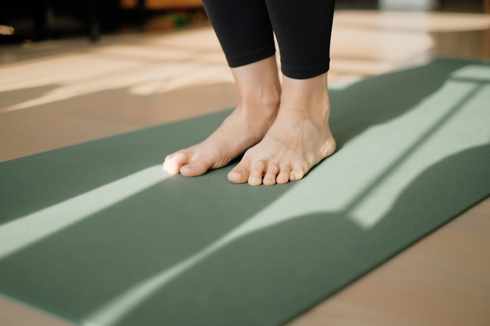 Eine Person, die auf einer Yogamatte auf dem Boden steht