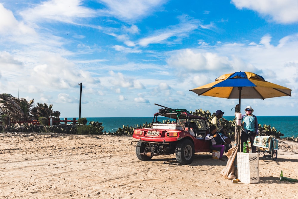 a group of people on a beach under an umbrella