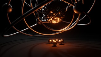 A 3D representation of an atomic structure with orbiting electrons. The nucleus is composed of tightly packed spheres and surrounded by several rings with individual spheres representing electrons. A warm glow illuminates the nucleus, casting shadows and reflections.