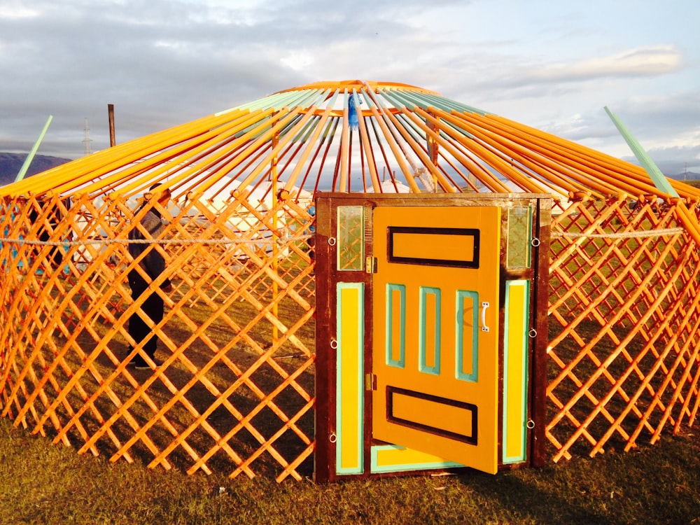 a yurt with a yellow door in the grass