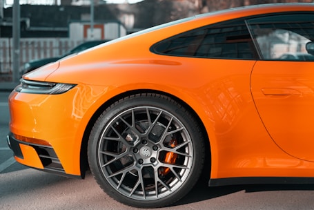an orange sports car parked in a parking lot