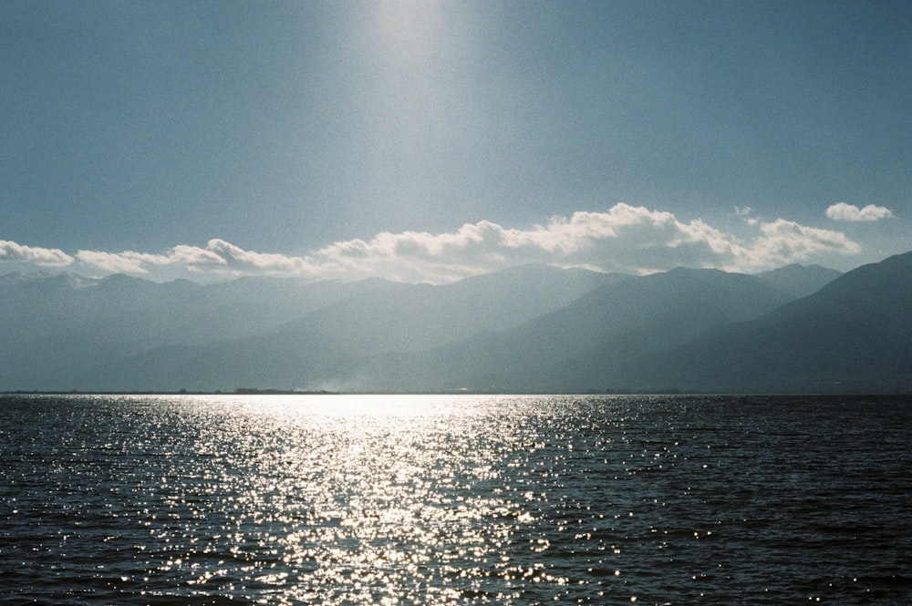 a large body of water with mountains in the background