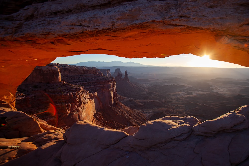 the sun is setting over a canyon in the desert