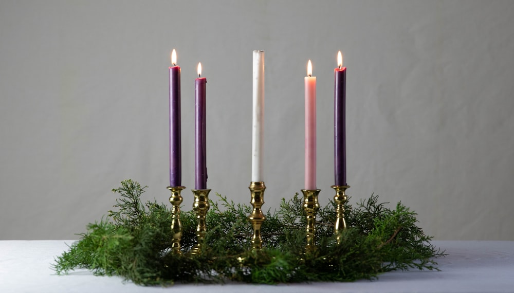 un gruppo di tre candele sedute in cima a un tavolo