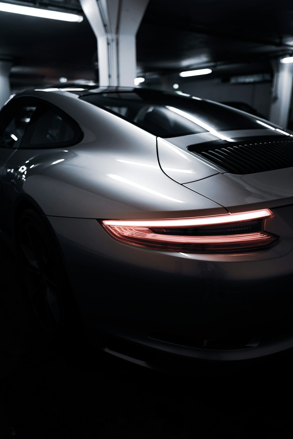 a silver sports car parked in a parking garage