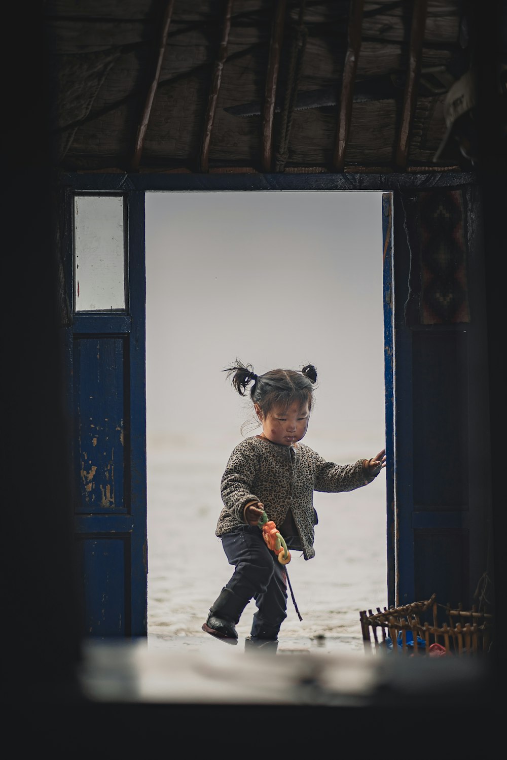 a little girl standing in a doorway of a building