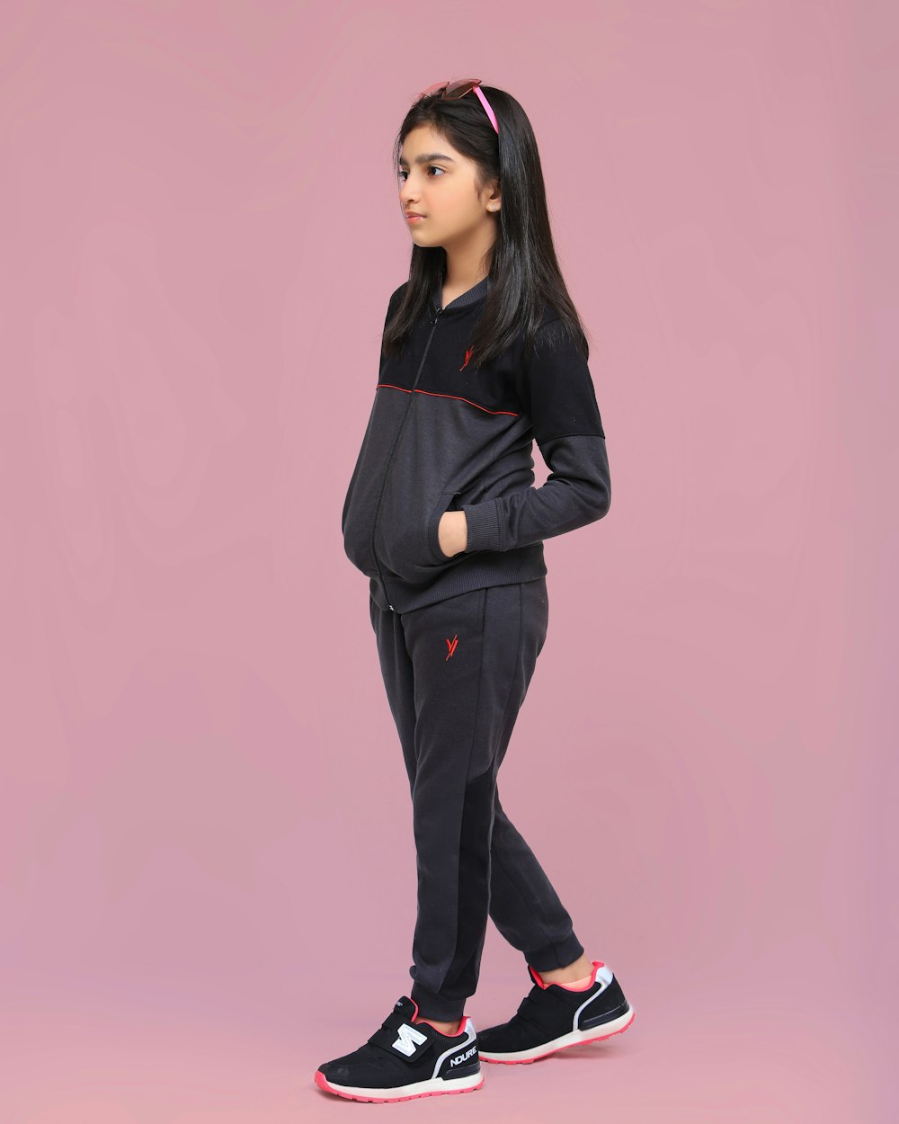 a young girl wearing a black sweatshirt and sweatpants