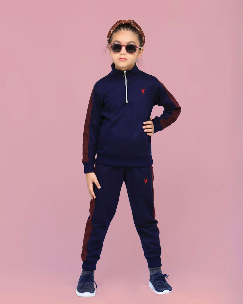a little girl wearing sunglasses and a purple outfit