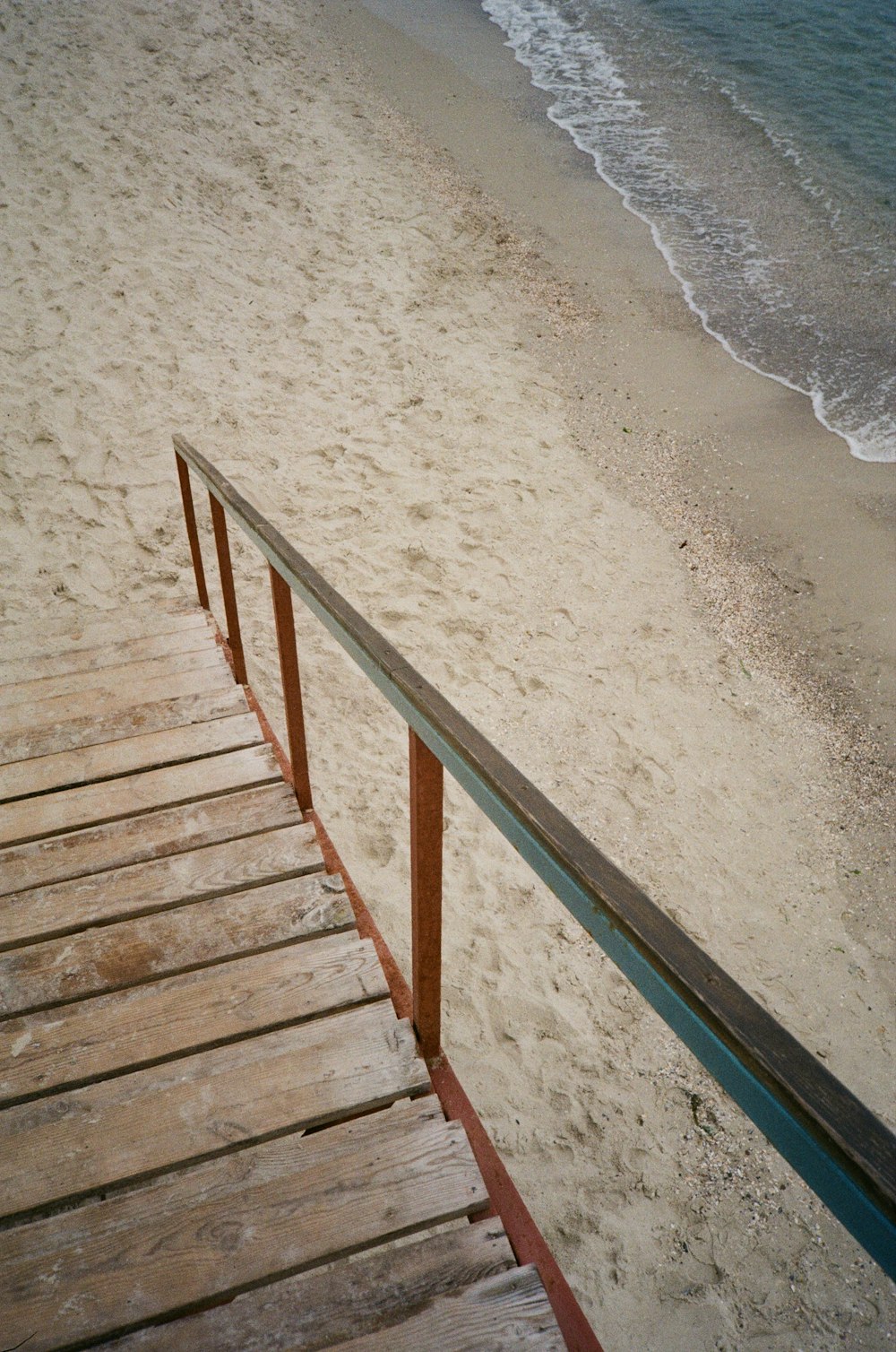 a view of a beach from a wooden walkway