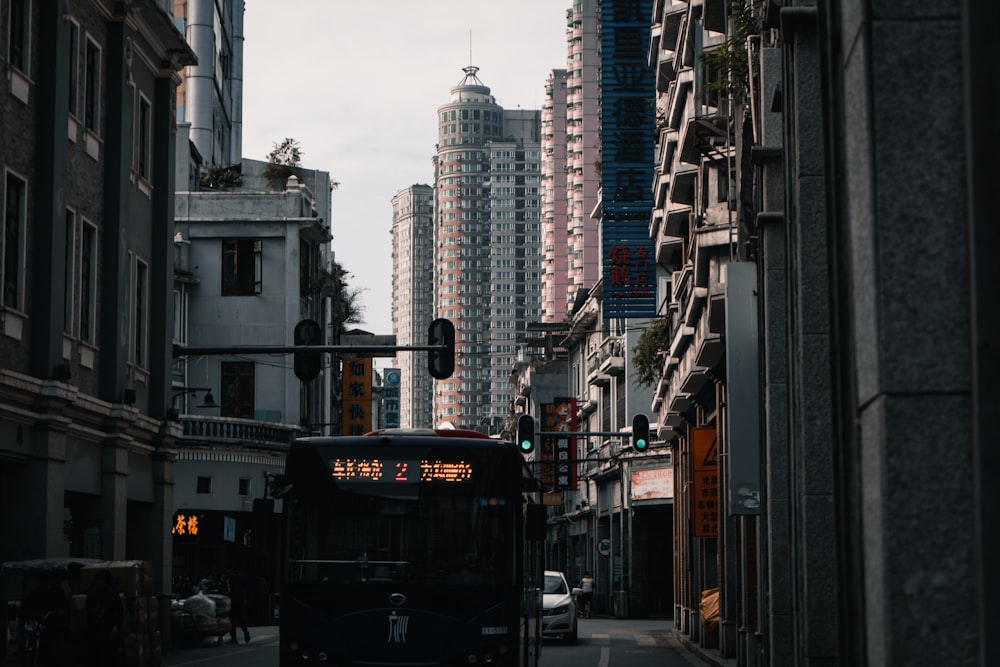 a bus driving down a street next to tall buildings