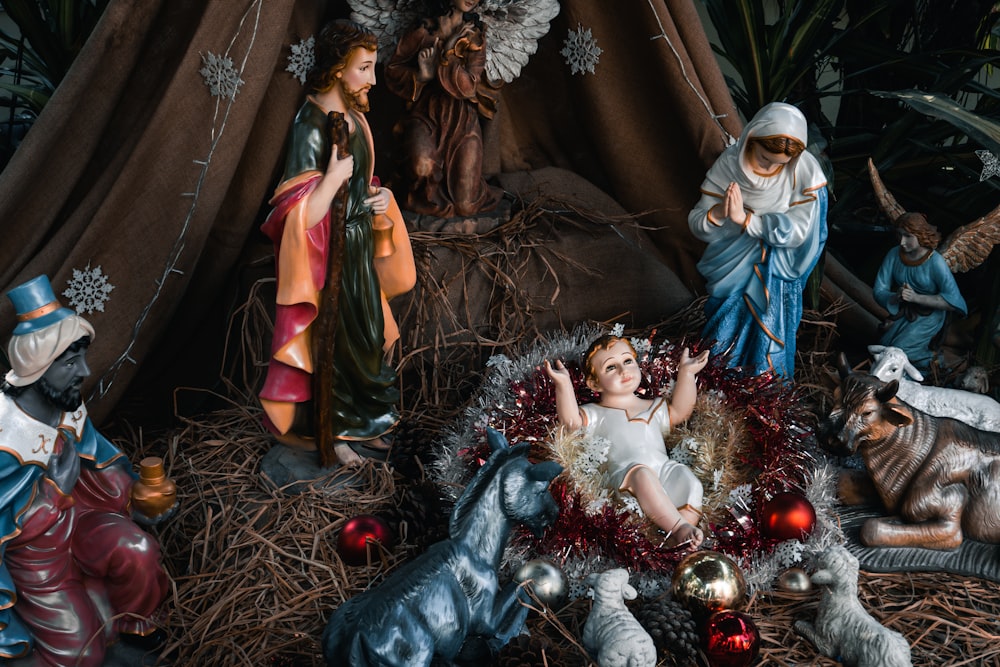 a nativity scene of a baby jesus surrounded by christmas decorations