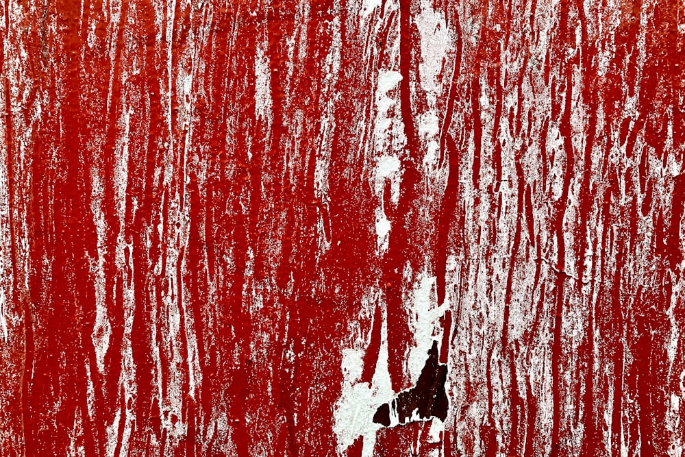 a red wall with white paint on it