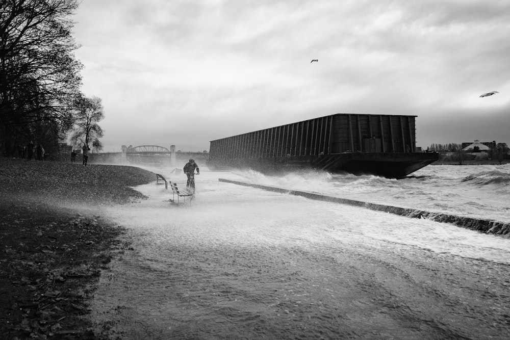 a black and white photo of a person riding a bike