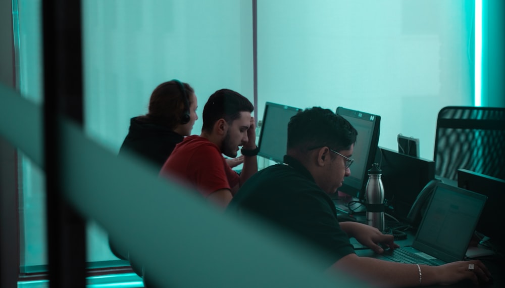 a man sitting at a desk using a laptop computer