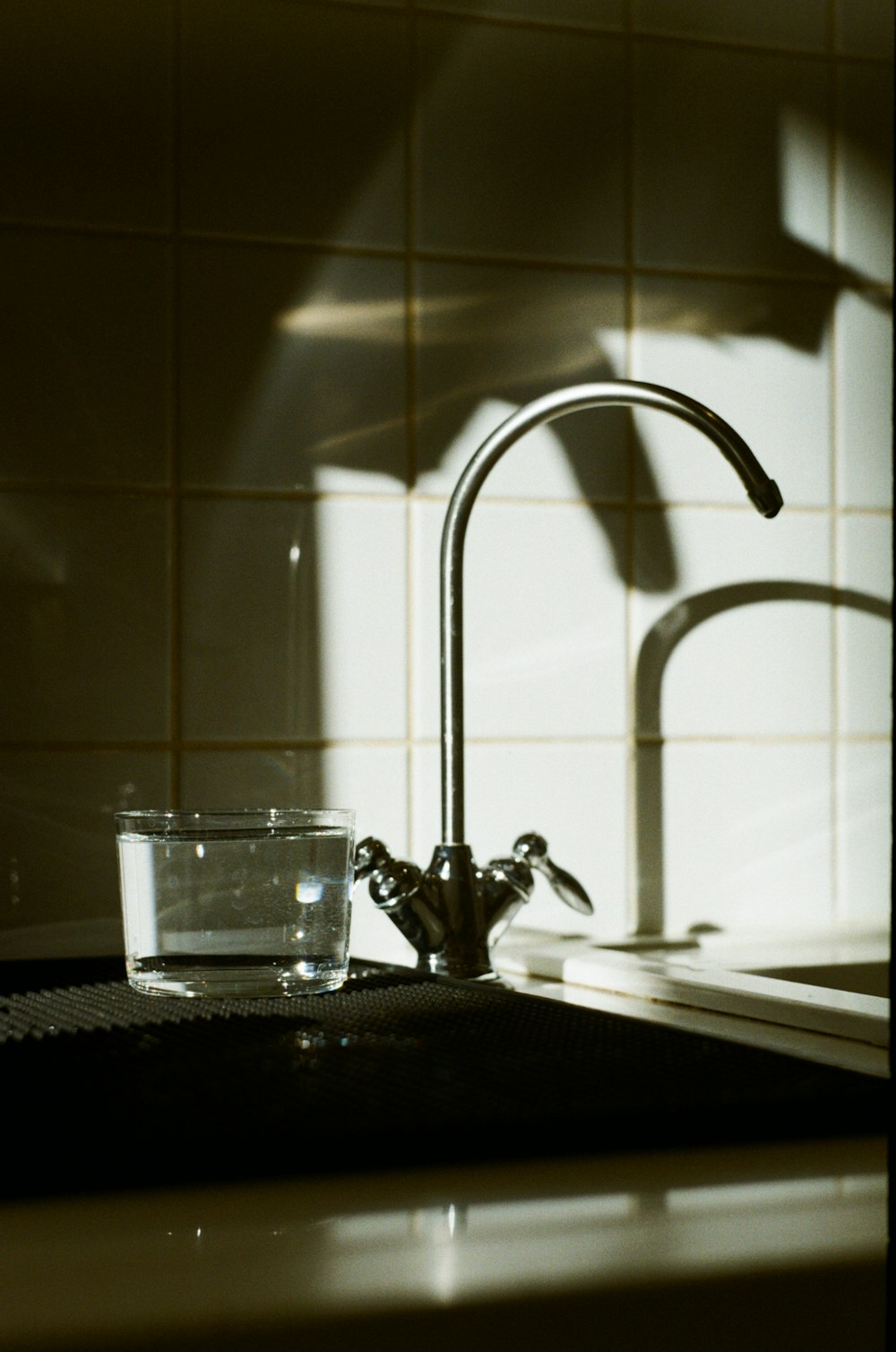 a sink with a faucet and a glass of water