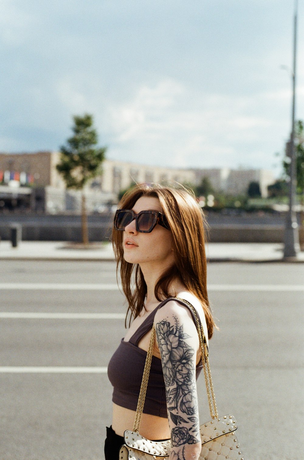 a woman with a tattoo on her arm holding a purse