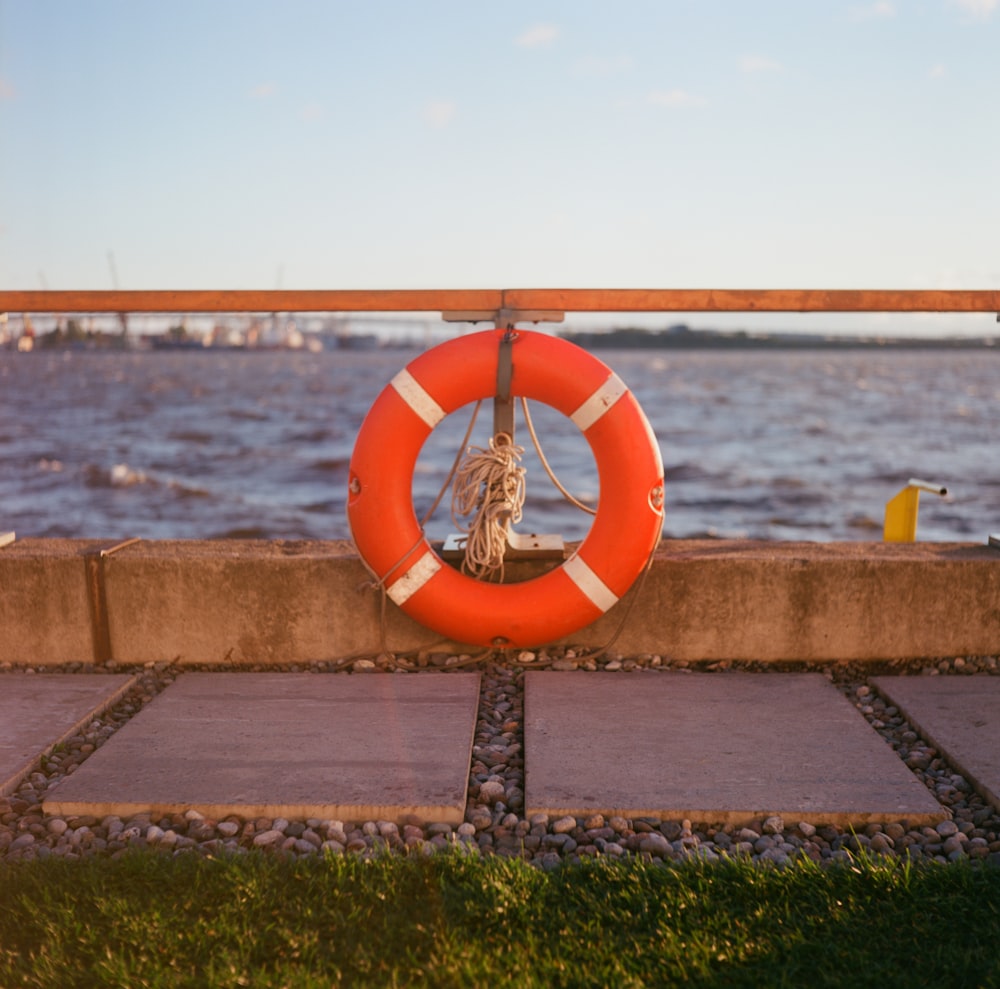 a life preserver on the edge of a walkway near the water