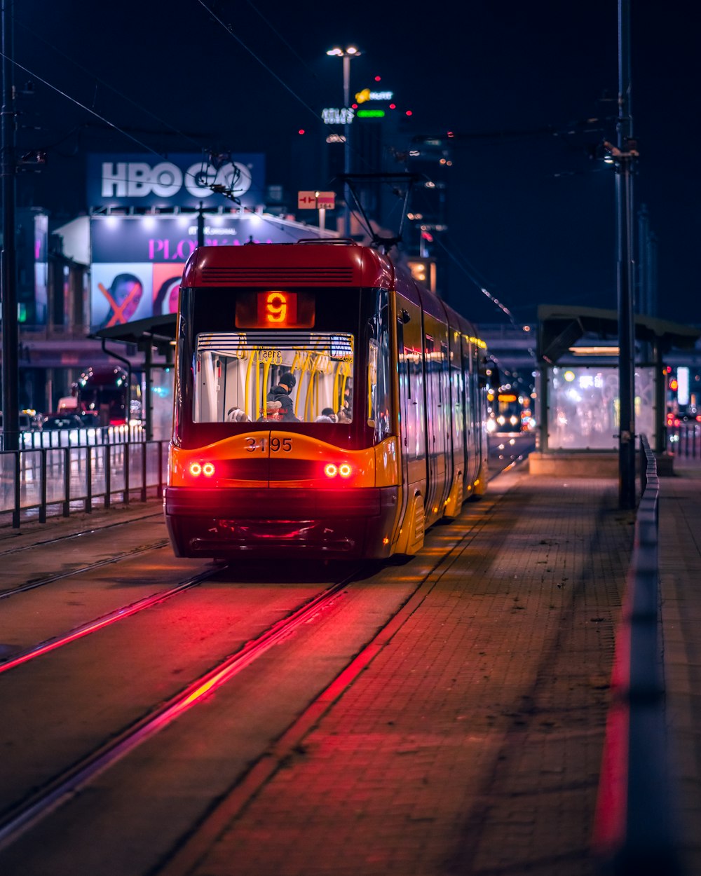 a red train traveling down train tracks at night