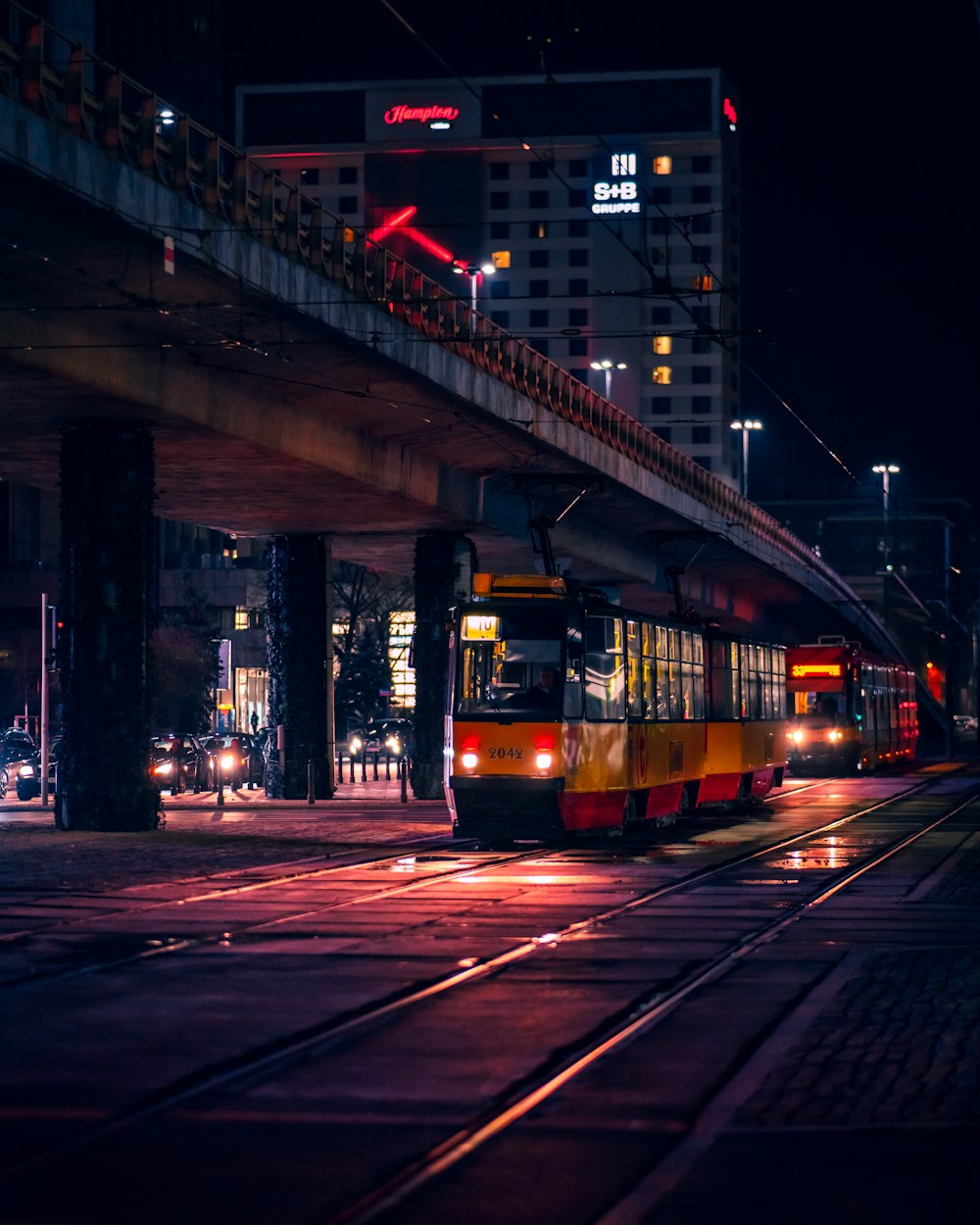 a train traveling under a bridge at night