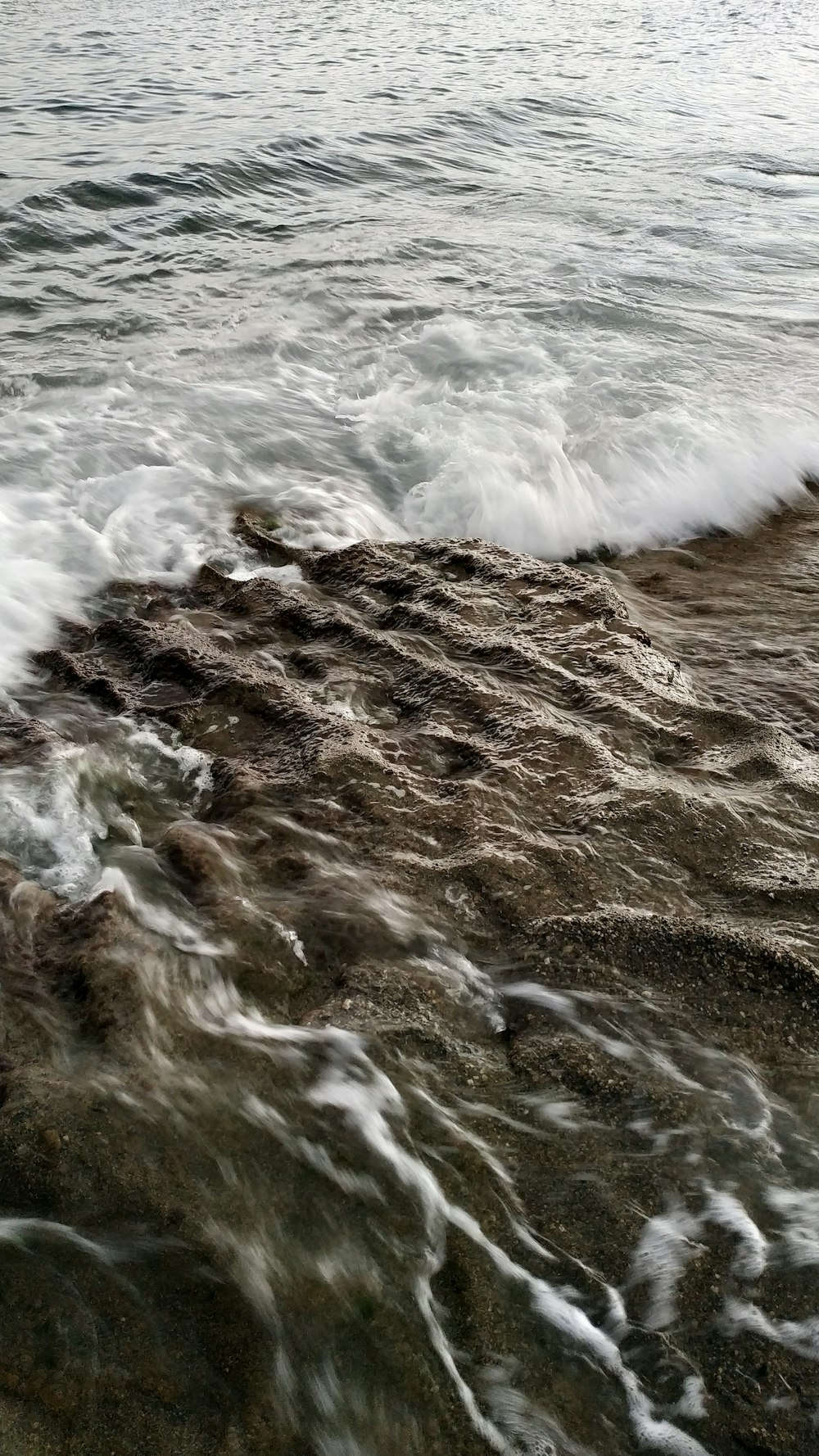 a person standing on a beach next to the ocean