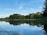 A serene landscape with a calm lake reflecting the sky, symbolizing tranquility.