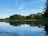A serene landscape with a calm lake reflecting the sky, symbolizing tranquility.