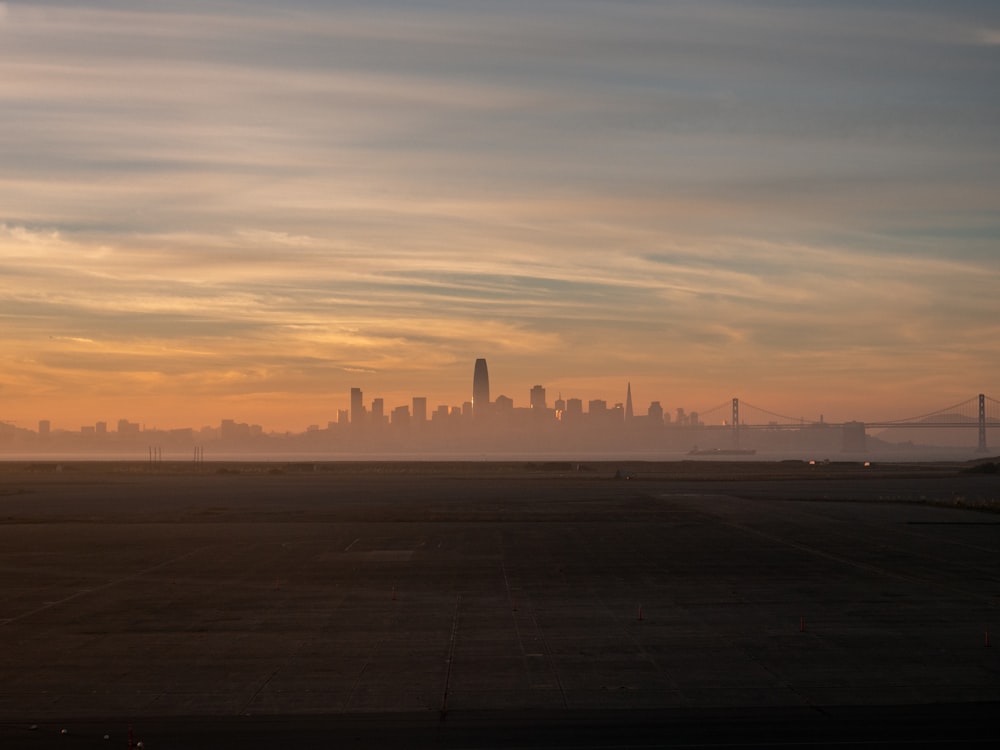 a city skyline in the distance with a plane in the foreground