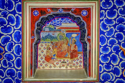 a blue and red wall with a painting on it
