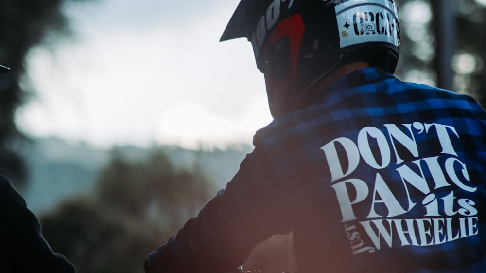 a man wearing a motorcycle helmet with the words don't panic on it