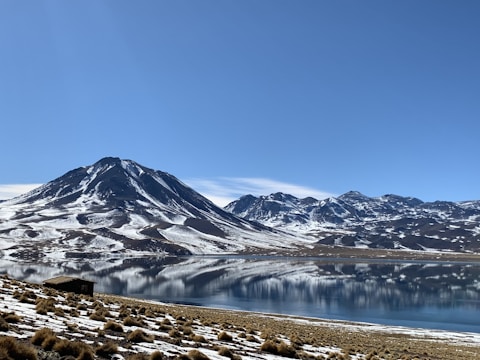 a mountain range with a lake in the foreground