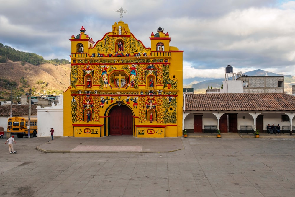 a yellow and red building with a clock on it