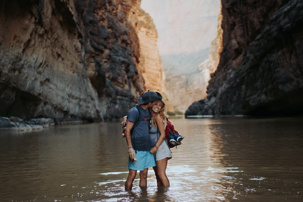 a couple of people standing in a river