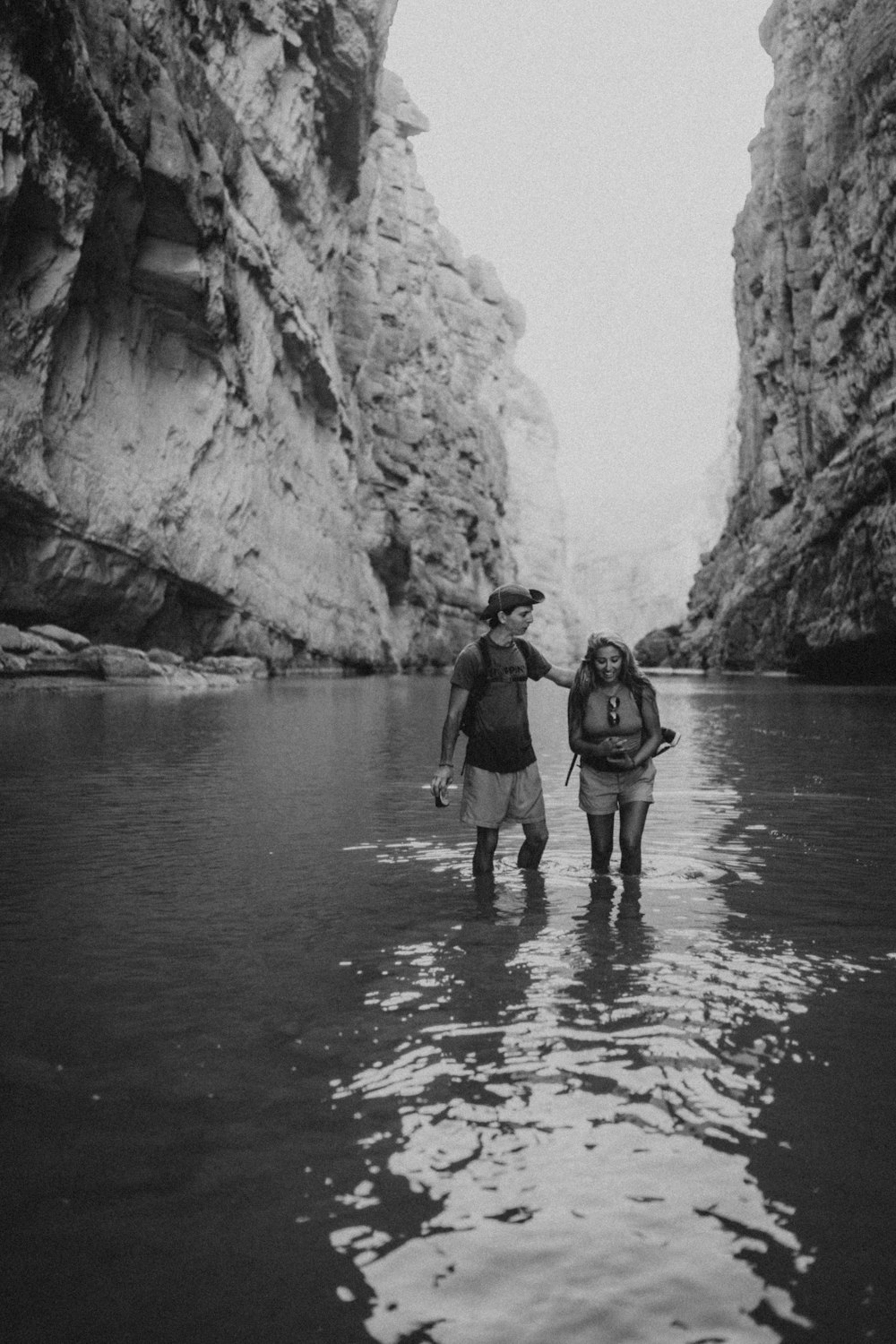 a couple of people standing in a river