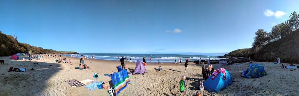 a group of people standing on top of a sandy beach