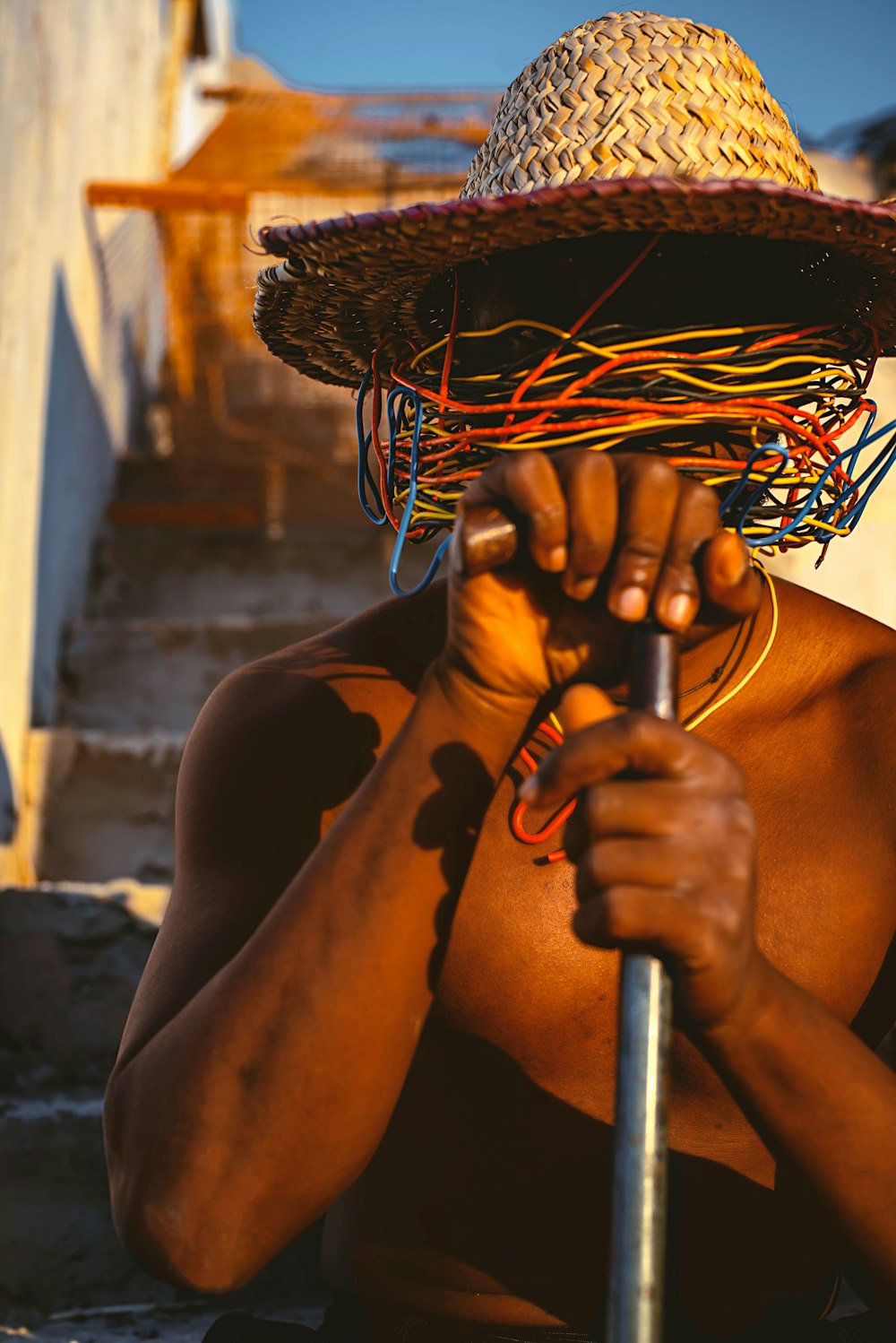 a man with a straw hat holding a stick